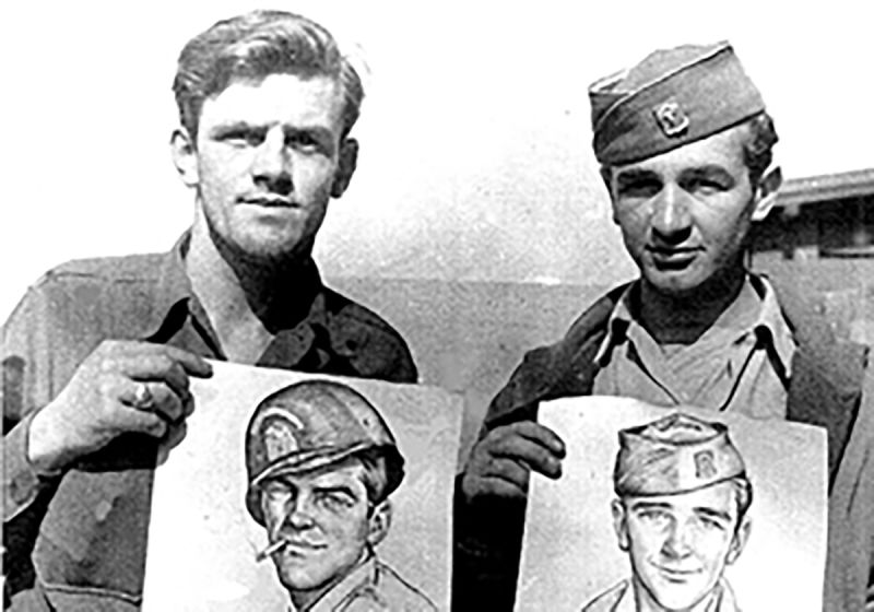 Roland and fellow combat engineer pose with drawings done by a USO Artist.